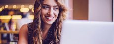 Frau lächelnd vor Laptop
