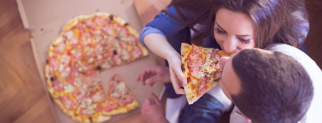 Mann und Frau essen Pizza beim ersten Treffen