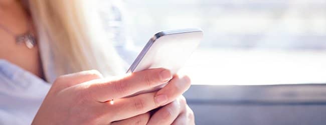 Frau mit Handy in der Hand macht Eifersucht Test