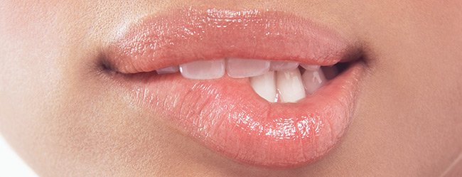 Lust auf Sex symbolisch dargestellt durch Nahaufnahme einer Frau die sich auf Lippe beißt