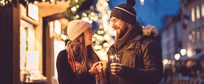 Mann und Frau mit Wunderkerzen als Symbol für Date-Ideen im Winter