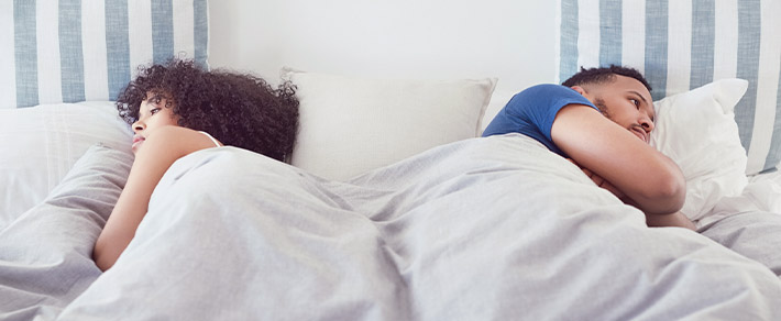 Ein Paar liegt im Bett, aber der Sex fällt aus
