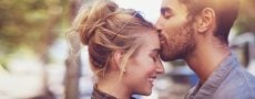 Mann küsst Frau auf die Stirn weil er den Beschützerinstinkt aus seiner Geschwisterkonstellation hat