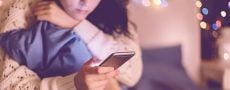 Frau schaut traurig in ihr Handy weil Sie Opfer von Benching geworden ist