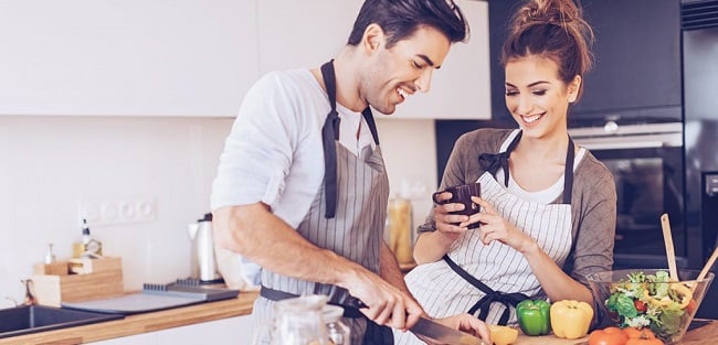 Frau macht Ihrem Mann die passenden Komplimente beim Kochen