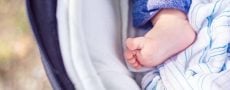 Ausschnitt Babyfuss im Kinderwagen als Zeichen für Torschlusspanik