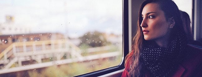 Unglücklich verliebte Frau sitzt im Zug