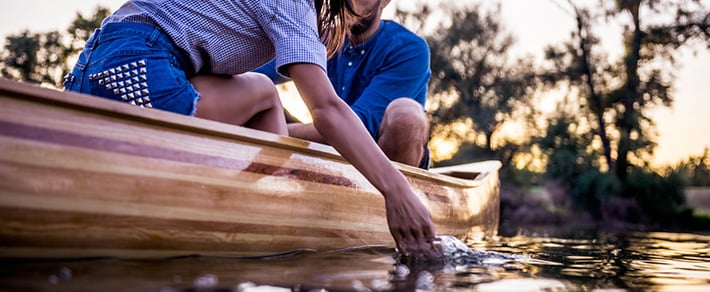 Mann und Frau fahren Kanu als Date-Idee für den Sommer