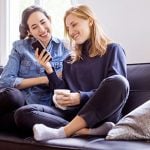 Zwei Frauen mit Handy unterhalten sich über Frauen anschreiben
