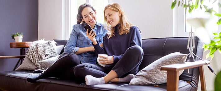 Zwei Frauen mit Handy unterhalten sich über Frauen anschreiben