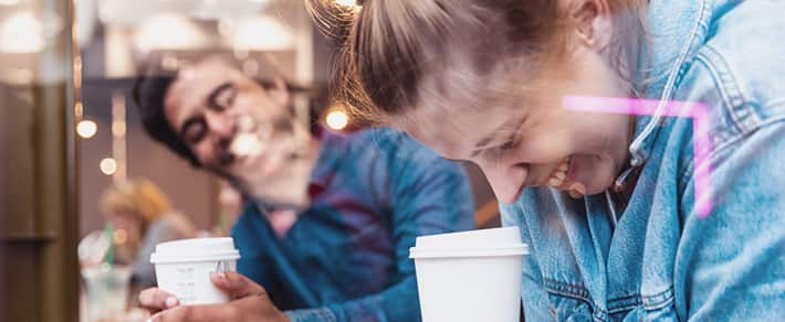 Mann und Frau lachen gemeinsam im Café beim Slow Dating