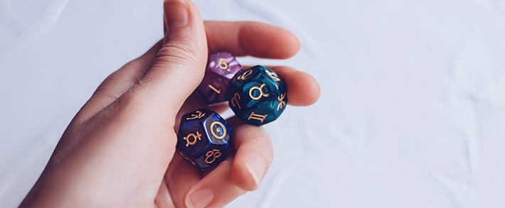 Eine Hand mit astrologischen Würfeln, der Glaube an Spiritualität und Astrologie in der Liebe ist jedoch unterschiedlich
