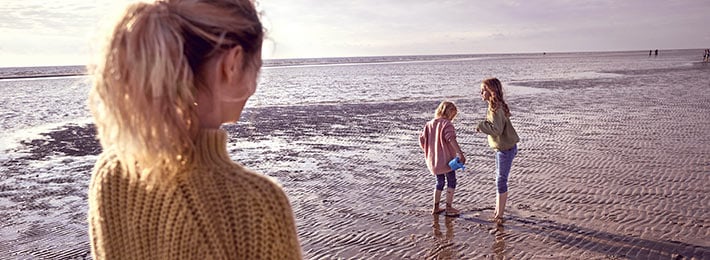 Eine Frau beobachtet zwei Kinder und fragt sich: was spricht eigentlich für und gegen die Familiengründung?