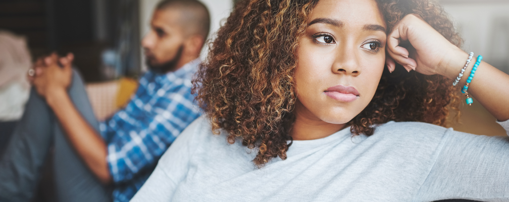 Mann und Frau sitzen auf einem Sofa und schauen frustriert.